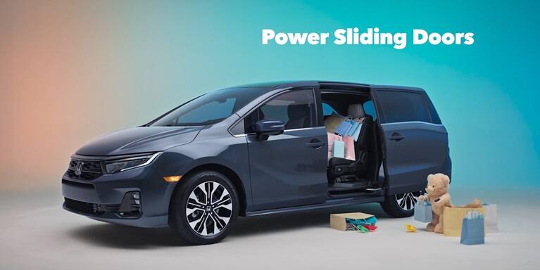 2027 Honda Odyssey Elite in Smoke Blue Pearl profile studio with shopping bags and power sliding doors (Minivan).